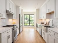 Modern galley kitchen with white cabinets and stainless steel appliances showing a parallel layout with clear walkway