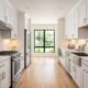 Modern galley kitchen with white cabinets and stainless steel appliances showing a parallel layout with clear walkway