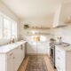 Small kitchen painted in warm off-white with seamless walls and ceiling making the space feel larger